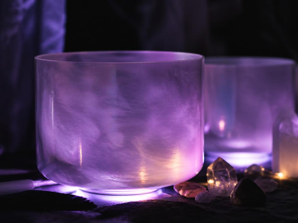 Crystal singing bowls glowing in purple light